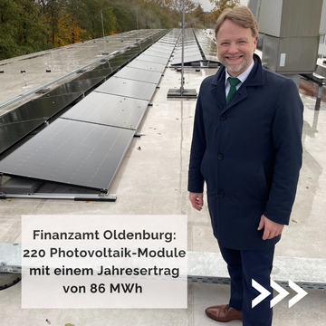 Minister Heere sehr erfreut auf dem Dach des Finanzamtes Oldenburg. Man sieht die installierten Module der PV-Anlage. Zitat: "Finanzamt Oldenburg: 220 Photovoltaik-Module mit einem Jahresertrag von 86 MWh."