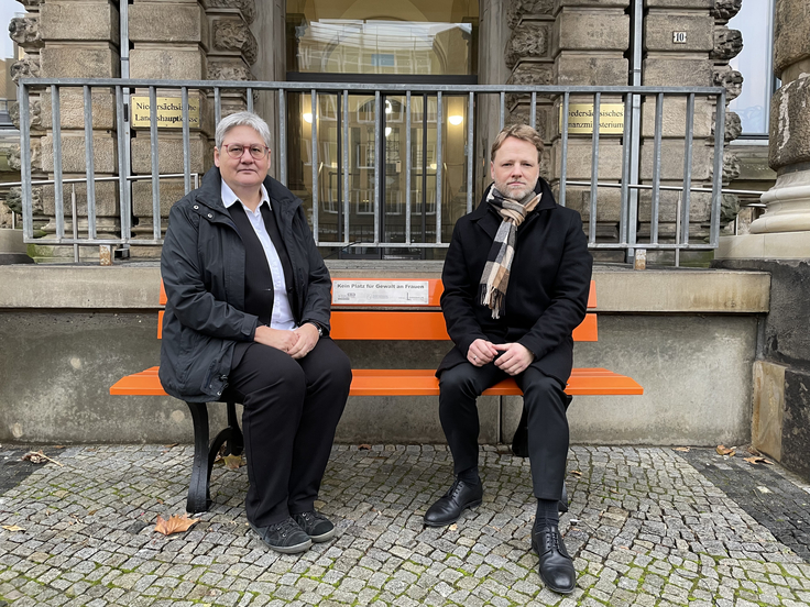 Finanzstaatsekretärin Sabine Tegtmeyer-Dette und Finanzminister Gerald Heere sitzen auf der OrangeBank vor dem Nds. Finanzministerium