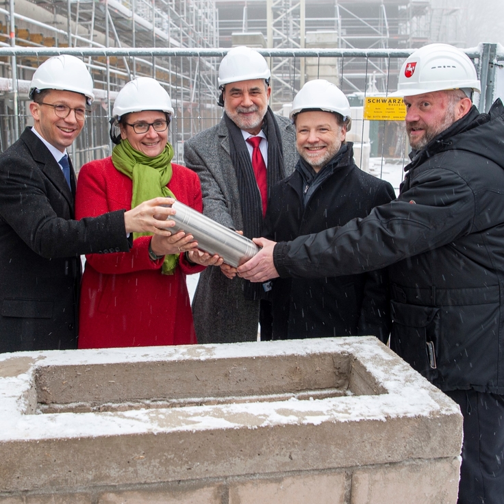 Die Zeitkapsel wird in den Grundstein gelegt (von links): Wissenschaftsminister F. Mohrs, Universitätspräsidentin Dr.-Ing. S. Schattauer, Prof. A. Adam (Chemie TU Clausthal), Finanzminister G. Heere und M. Rogge, Leiter des SBN Süd-Nds.